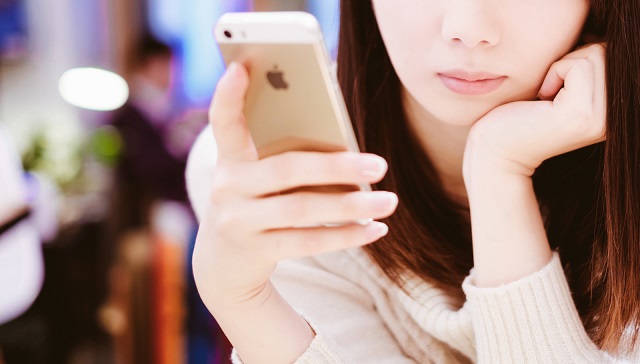 スマホをいじる女性